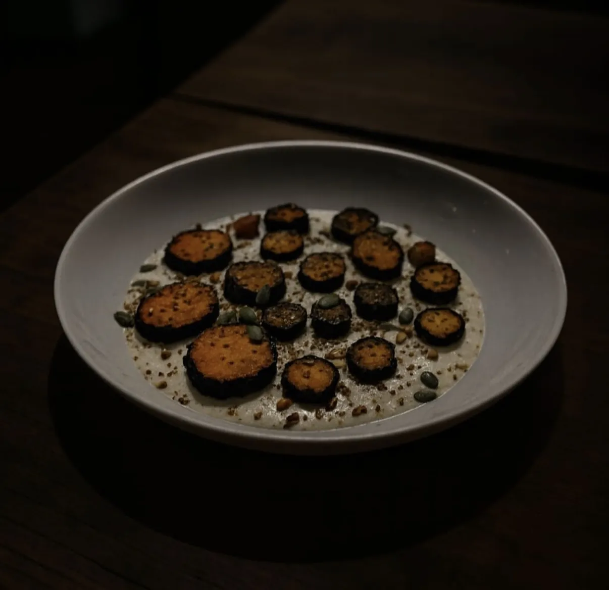 Rodajas asadas sobre una crema clara en plato hondo